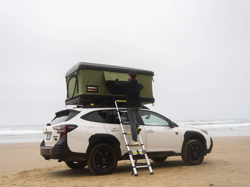 Rolling up the windows of the TentBox Classic 2.0 in Forest Green at the beach