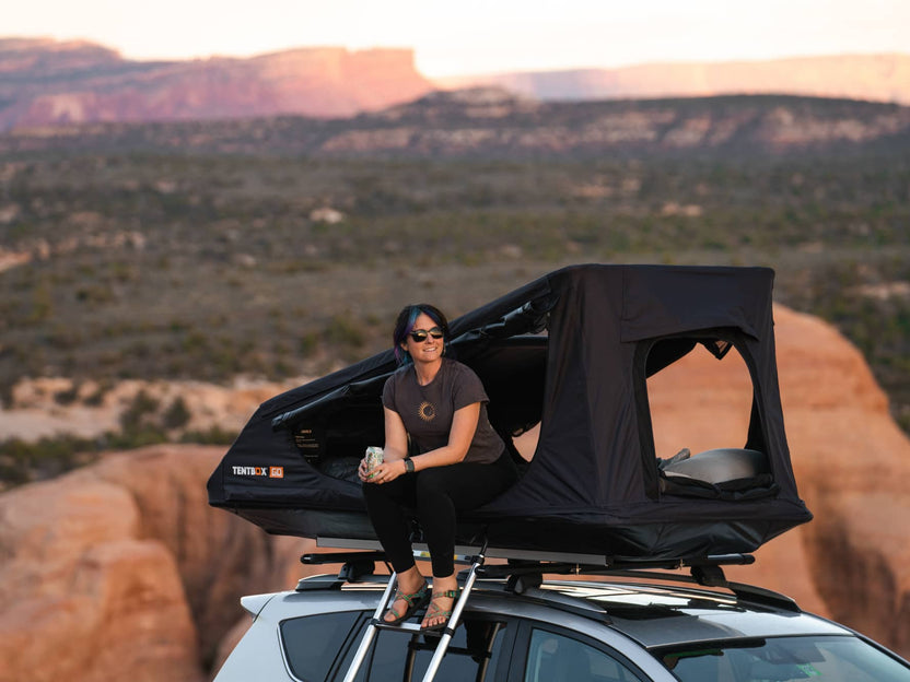 Woman enjoying the Utah desert sunset views from the side of the TentBox GO rooftop tent