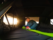Man enjoying the views and the spacious interiors of the TentBox Lite XL rooftop tent