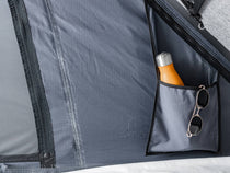 The internal pocket in a TentBox Cargo, with a bottle and sun glasses stored inside the pocket